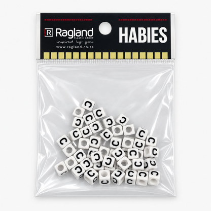 A clear plastic zip-top bag containing many small white cube beads printed with a black letter C, attached to a black Ragland brand header card that reads HABIES.