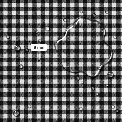 Black and white gingham fabric surface with scattered water droplets and a larger irregular droplet, plus a label reading 9 mm indicating fabric scale
