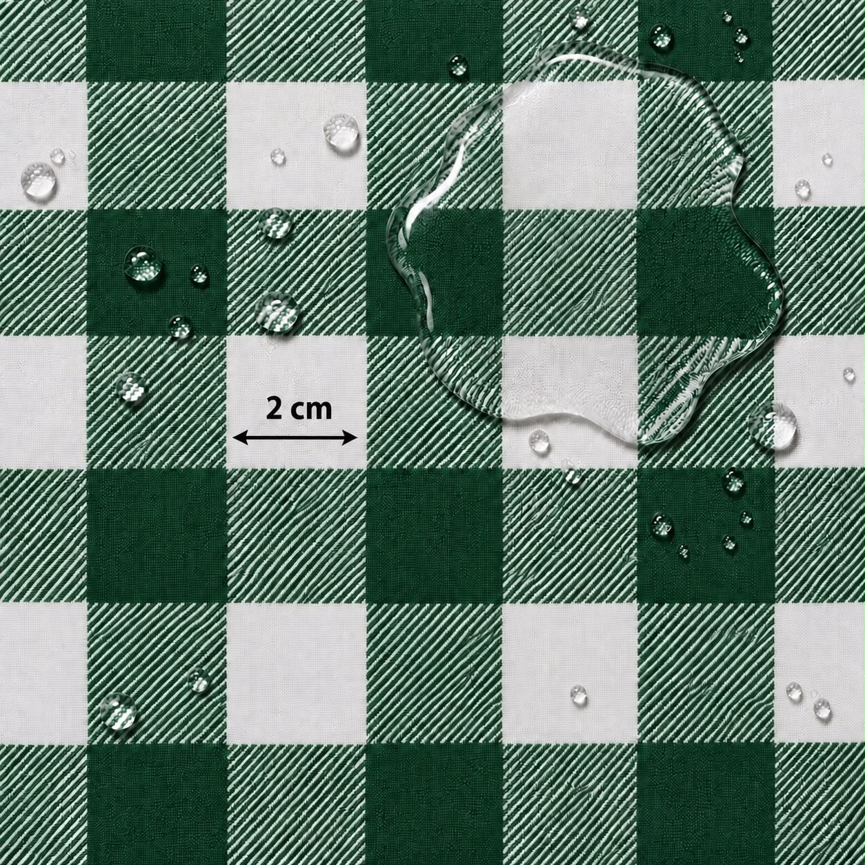 Green and white checkered fabric surface with water droplets and a large puddle on top, plus a small '2 cm' scale marker.
