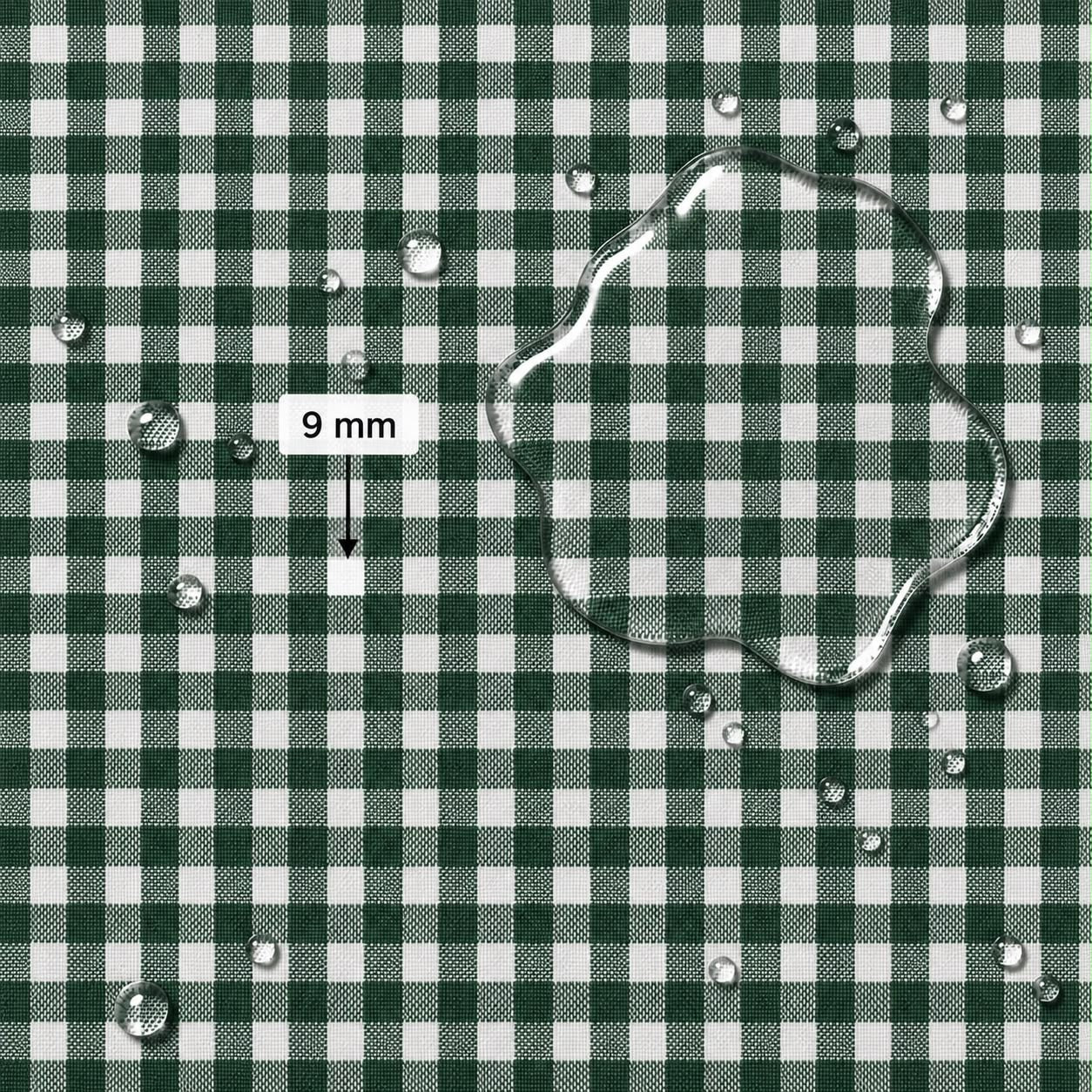 A close-up of a green and white gingham fabric surface with water droplets and a large transparent water puddle on top. A label reads “9 mm” with an arrow pointing to the puddle, indicating pattern scale.