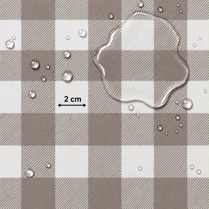 A close-up of a brown and white buffalo plaid fabric surface with water droplets and a clear liquid puddle on top, plus a black measurement arrow labeled 2 cm.