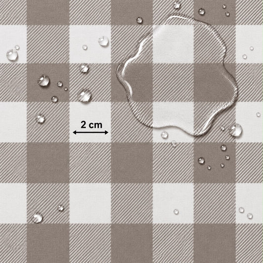 A close-up of a brown and white buffalo plaid fabric surface with water droplets and a clear liquid puddle on top, plus a black measurement arrow labeled 2 cm.