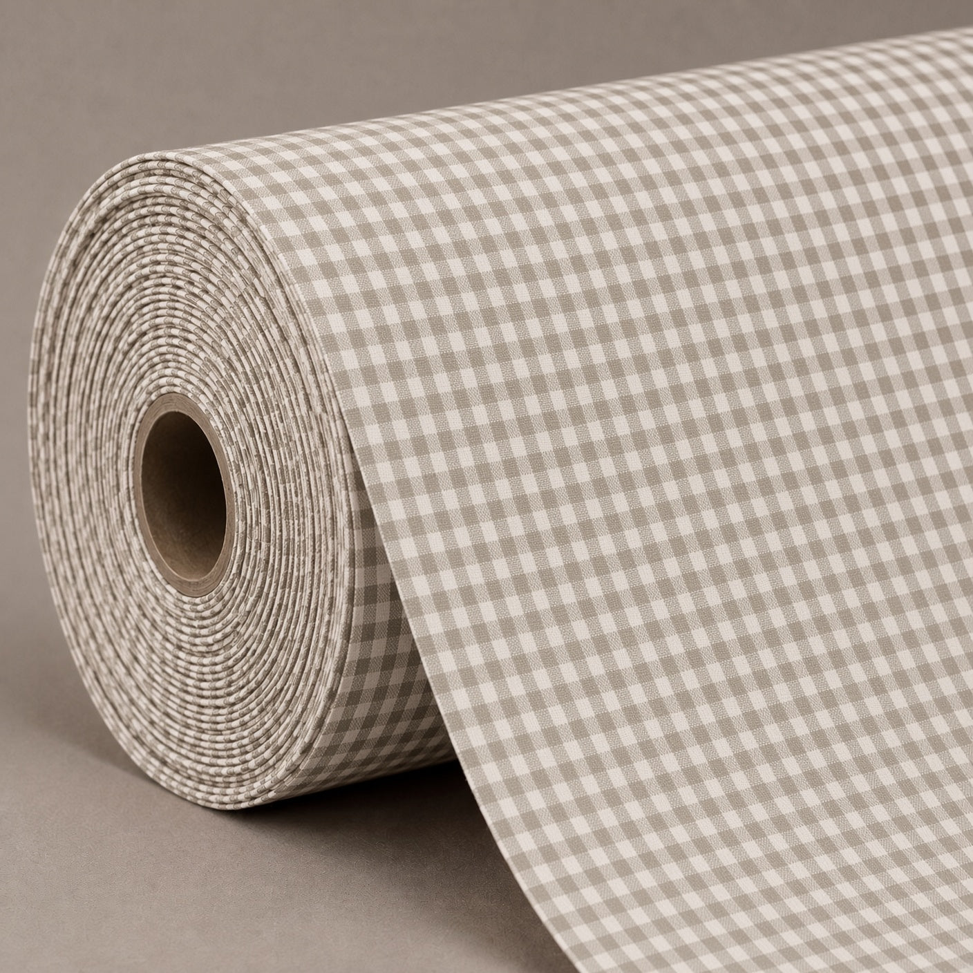 A roll of beige and gray gingham checkered wrapping paper or fabric, partially unrolled on a neutral gray background.