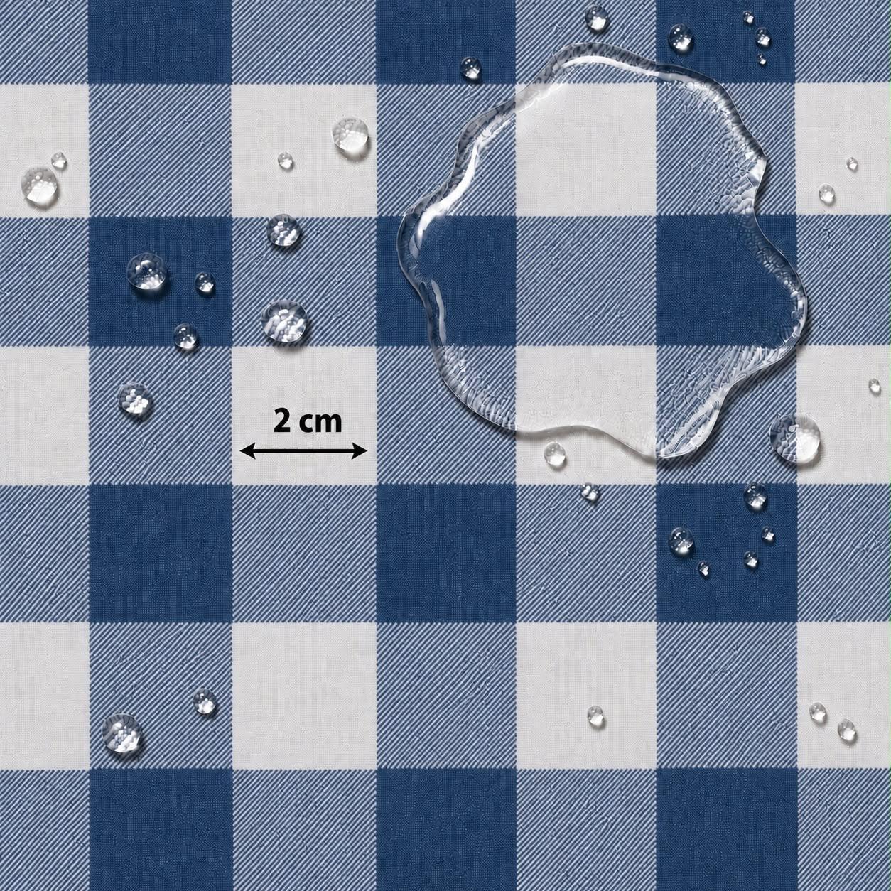 Blue and white checkered fabric surface with water droplets and a clear puddle on top, plus a small '2 cm' scale marker.