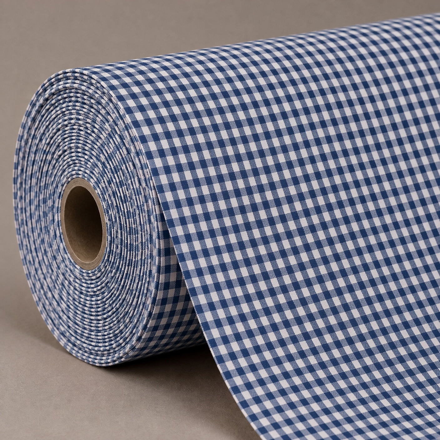 A roll of blue and white gingham patterned fabric or wrapping paper, partially unrolled, set against a neutral gray background.
