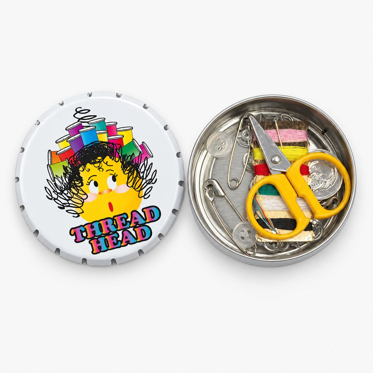 A circular metal sewing tool tin shown open on a light gray background. The lid features a cartoon illustration of a yellow character with colorful thread spools on its head and the words 'THREAD HEAD'.