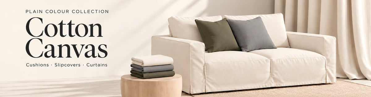 Cotton Canvas plain colour collection: natural canvas slipcovered sofa, grey and dark olive cushions, curtains and folded fabrics.